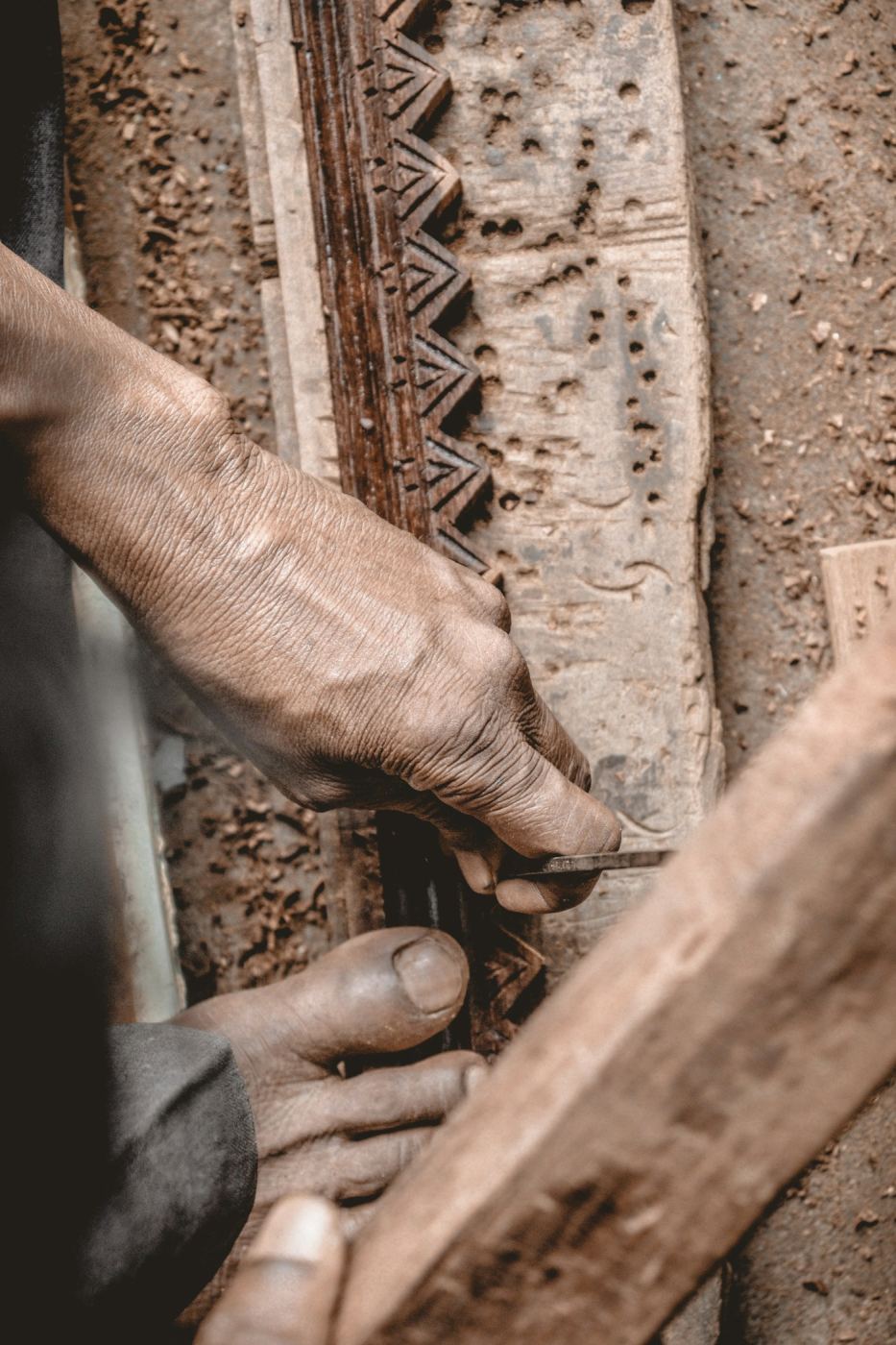 Hands carving a block of wood